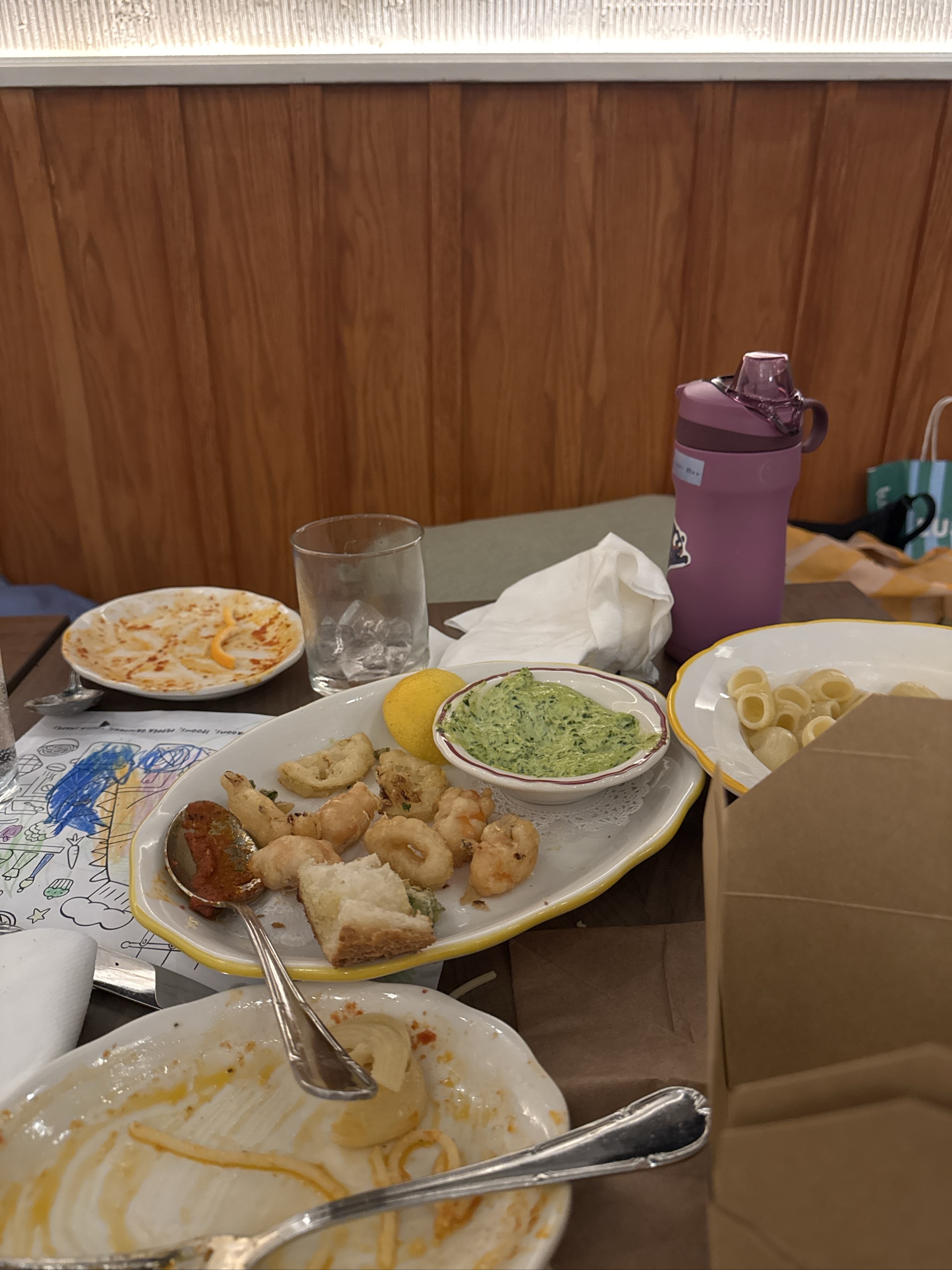 Restaurant table with appetizer platter, plates, and purple water bottle