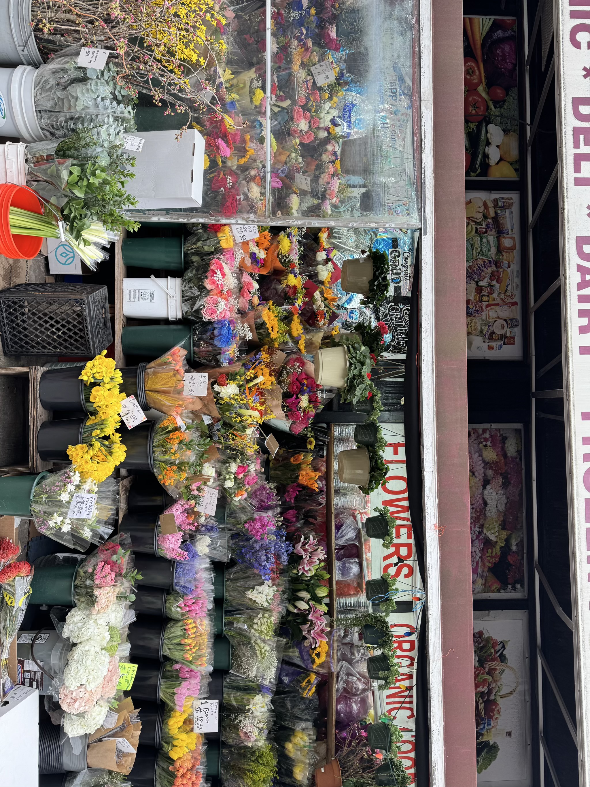 Colorful flower shop display with various fresh blooms and arrangements.