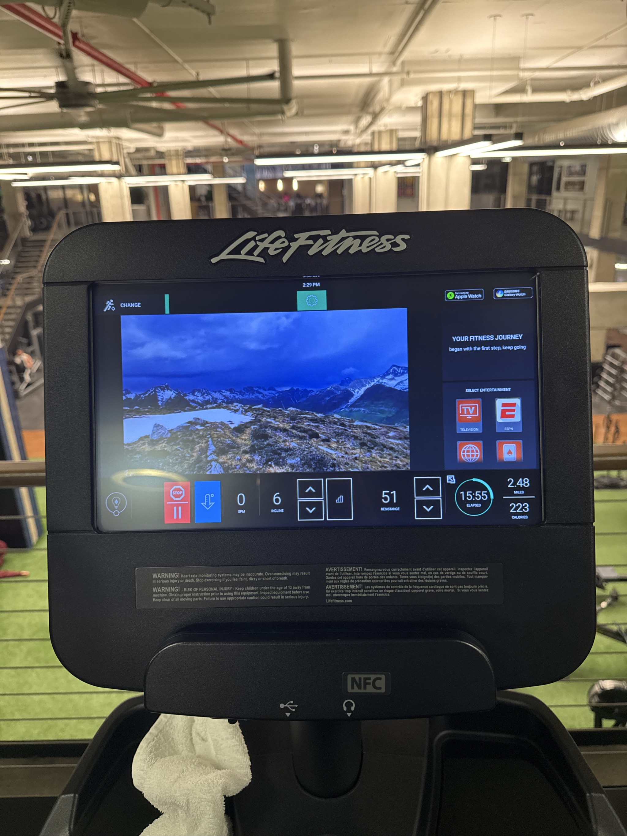 Life Fitness treadmill display showing mountain scenery and workout metrics.