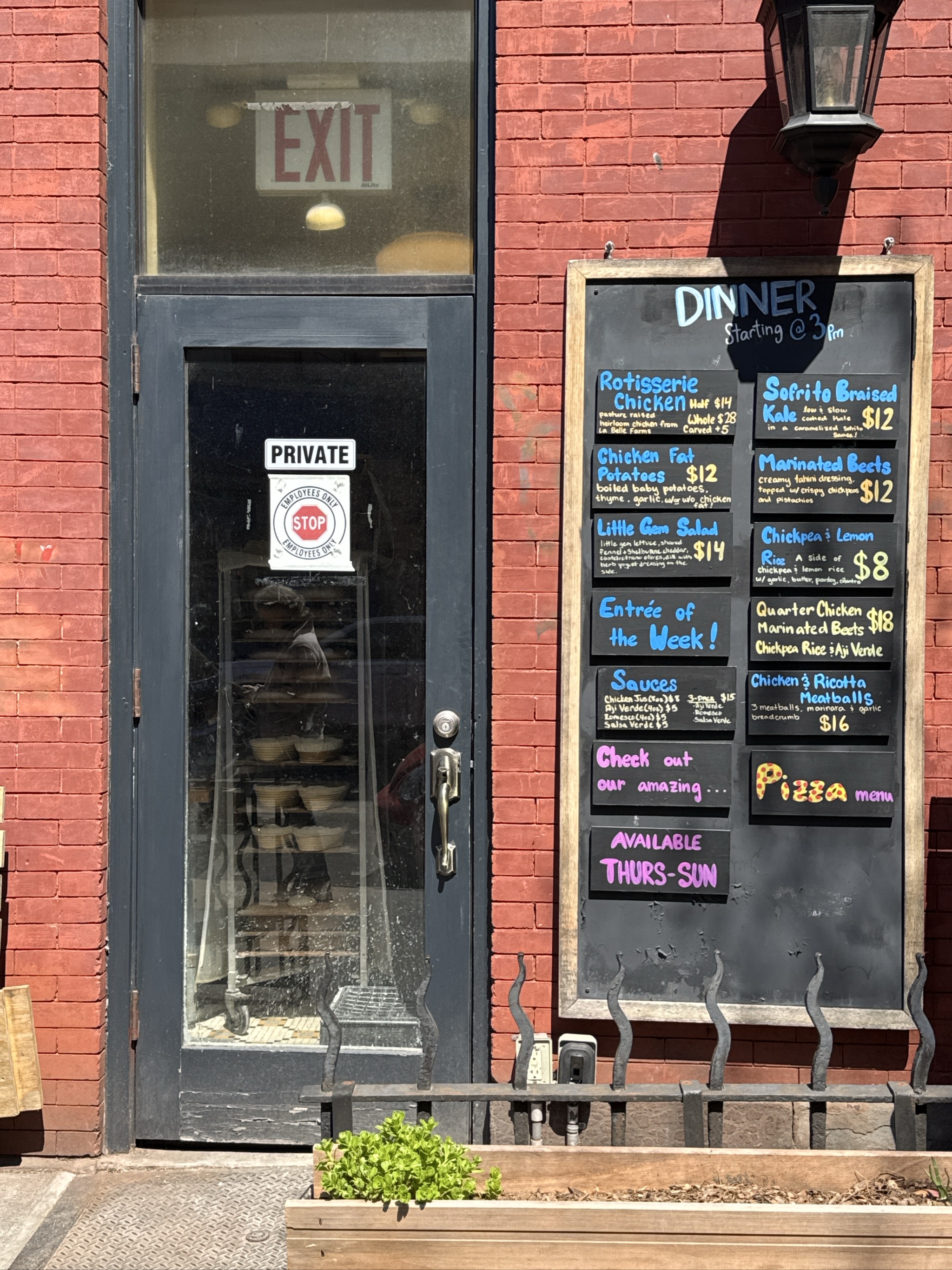 Restaurant entrance with dinner menu board and private employee door.