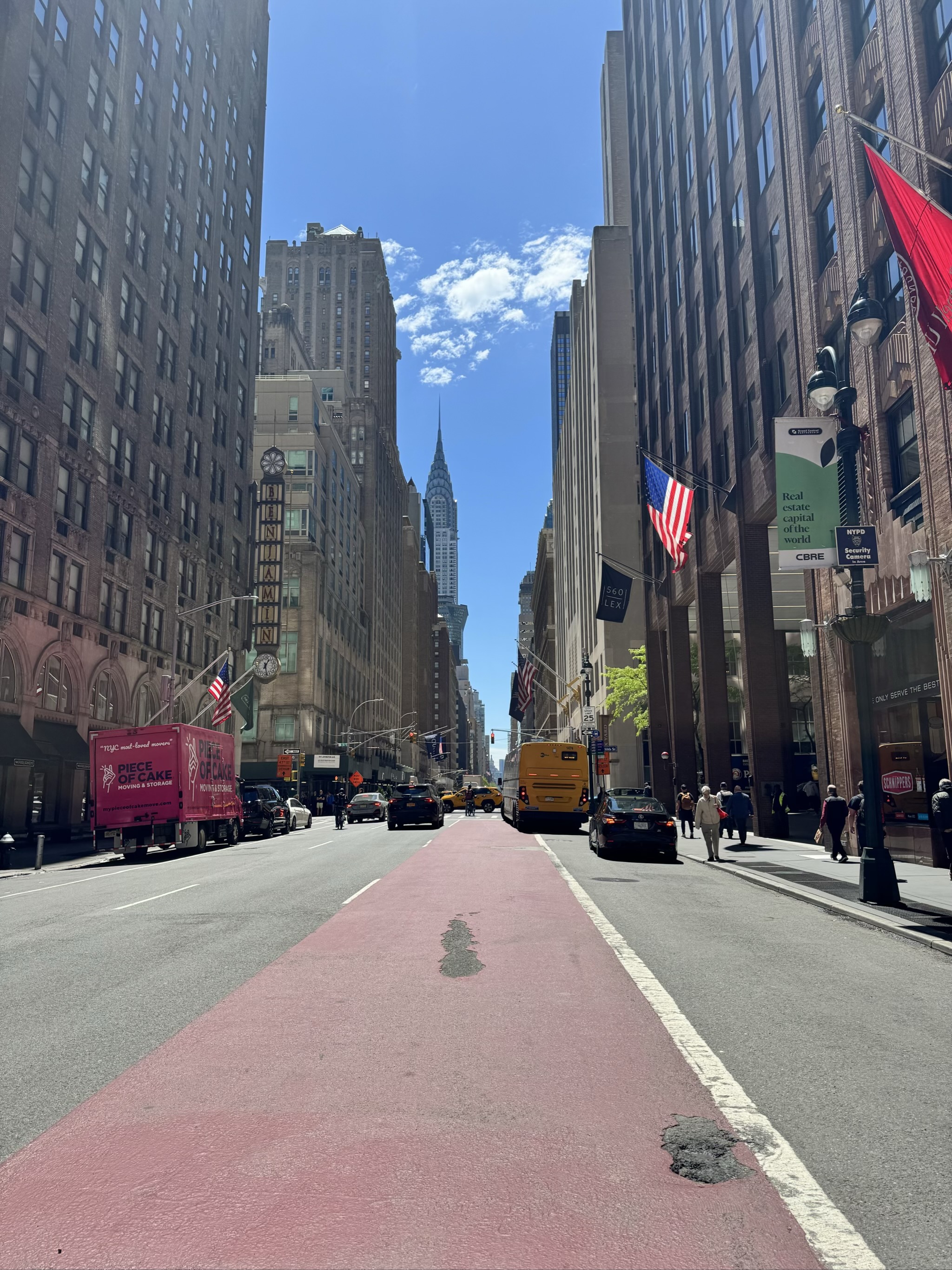 Busy Manhattan street with tall buildings and Chrysler Building visible.
