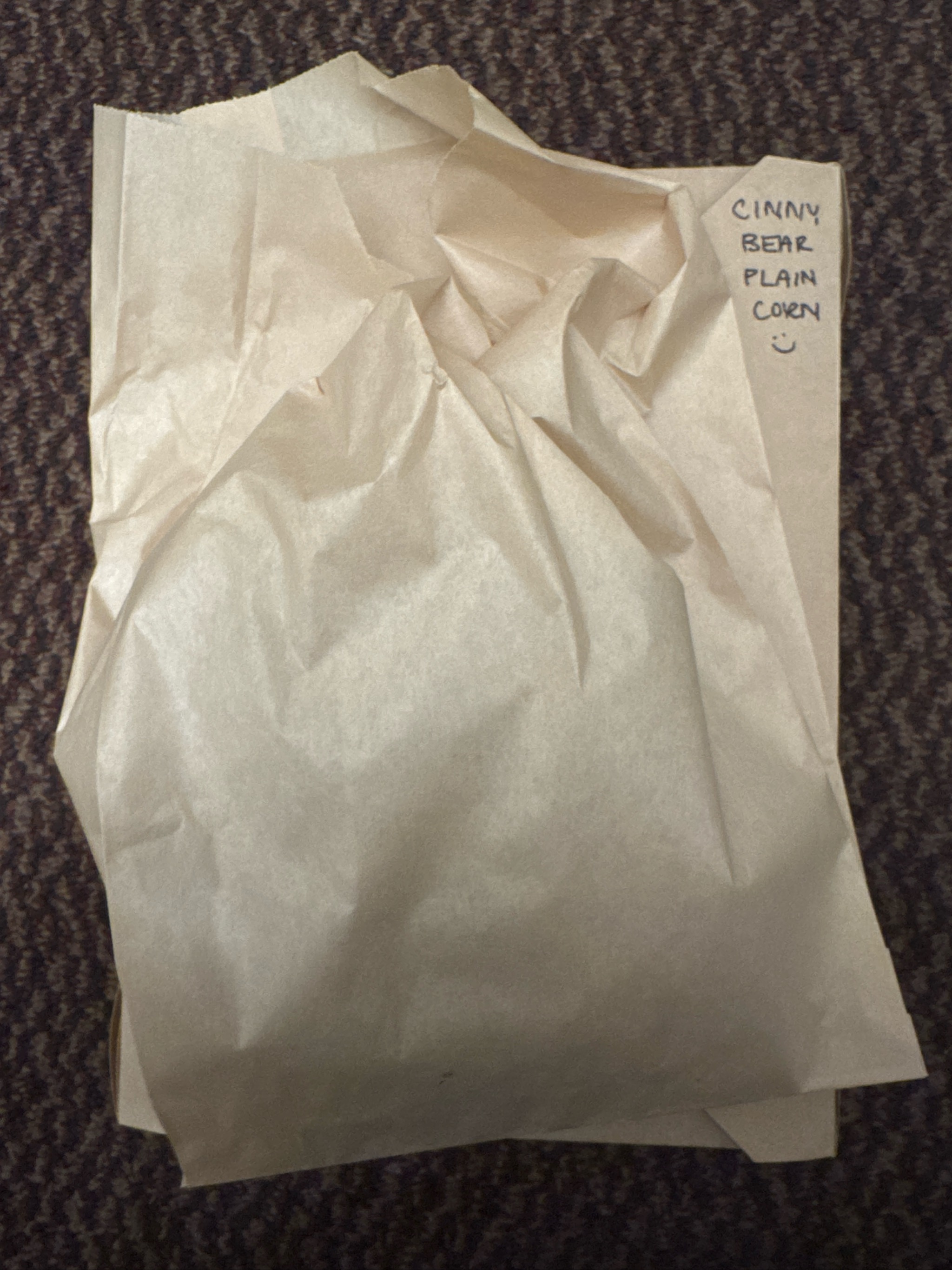 White paper bag with "GINNY BEAR PLAIN CORN" handwritten label.